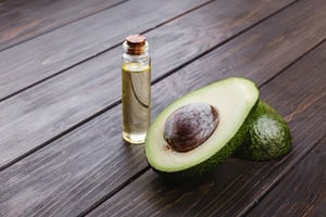 little-bottle-with-oil-avocado-stand-wooden-table