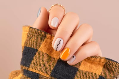 manicured-womans-hand-close-up-beige-background-minimal-spring-autumn-nail-design