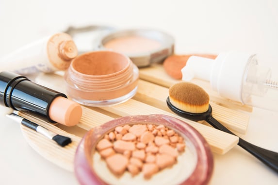 primer-plano-cosmeticos-mujer-utiliza-polvo-maquillaje-cepillo-pintalabios-crema